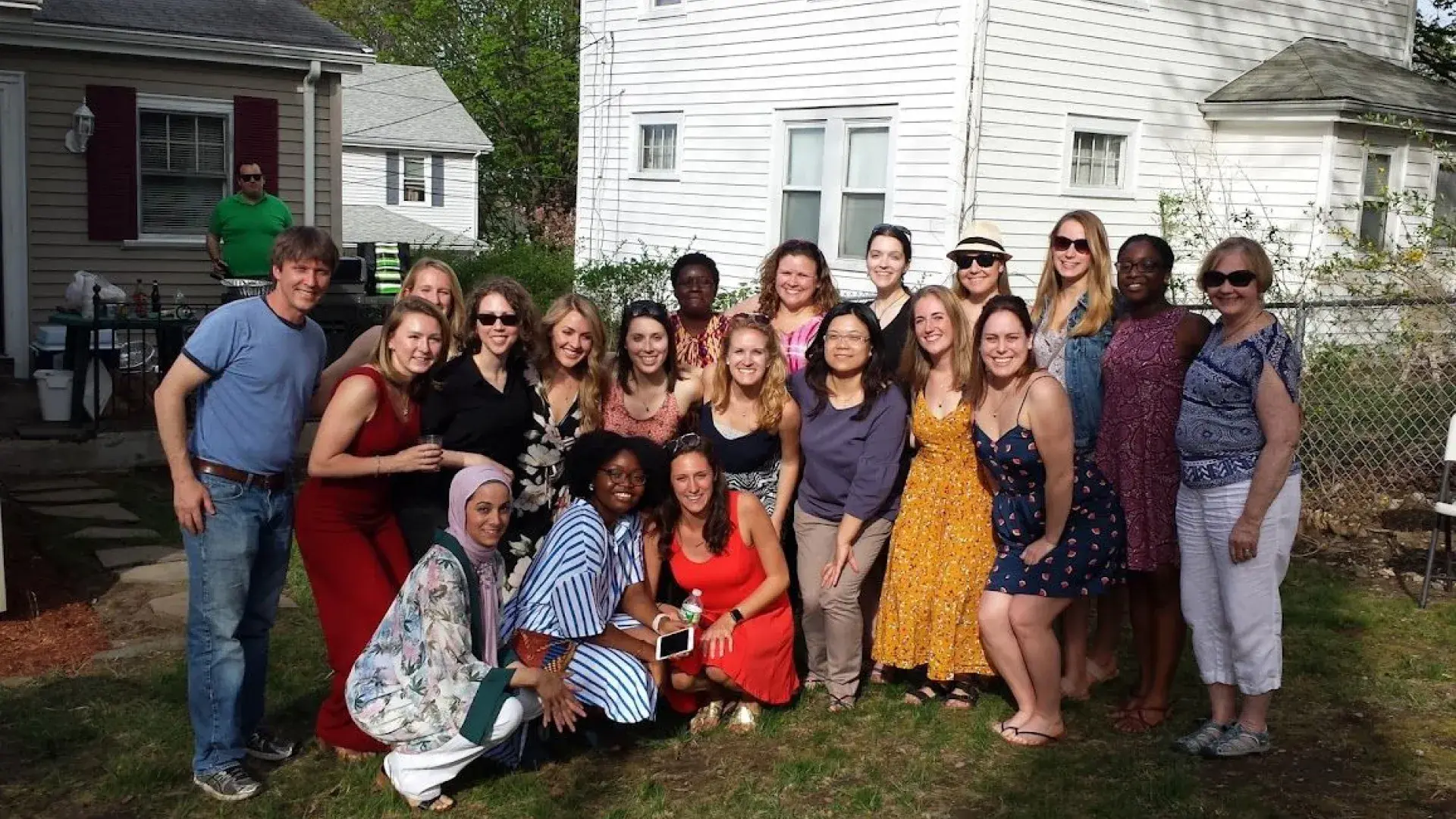 A group of people pose in a yard