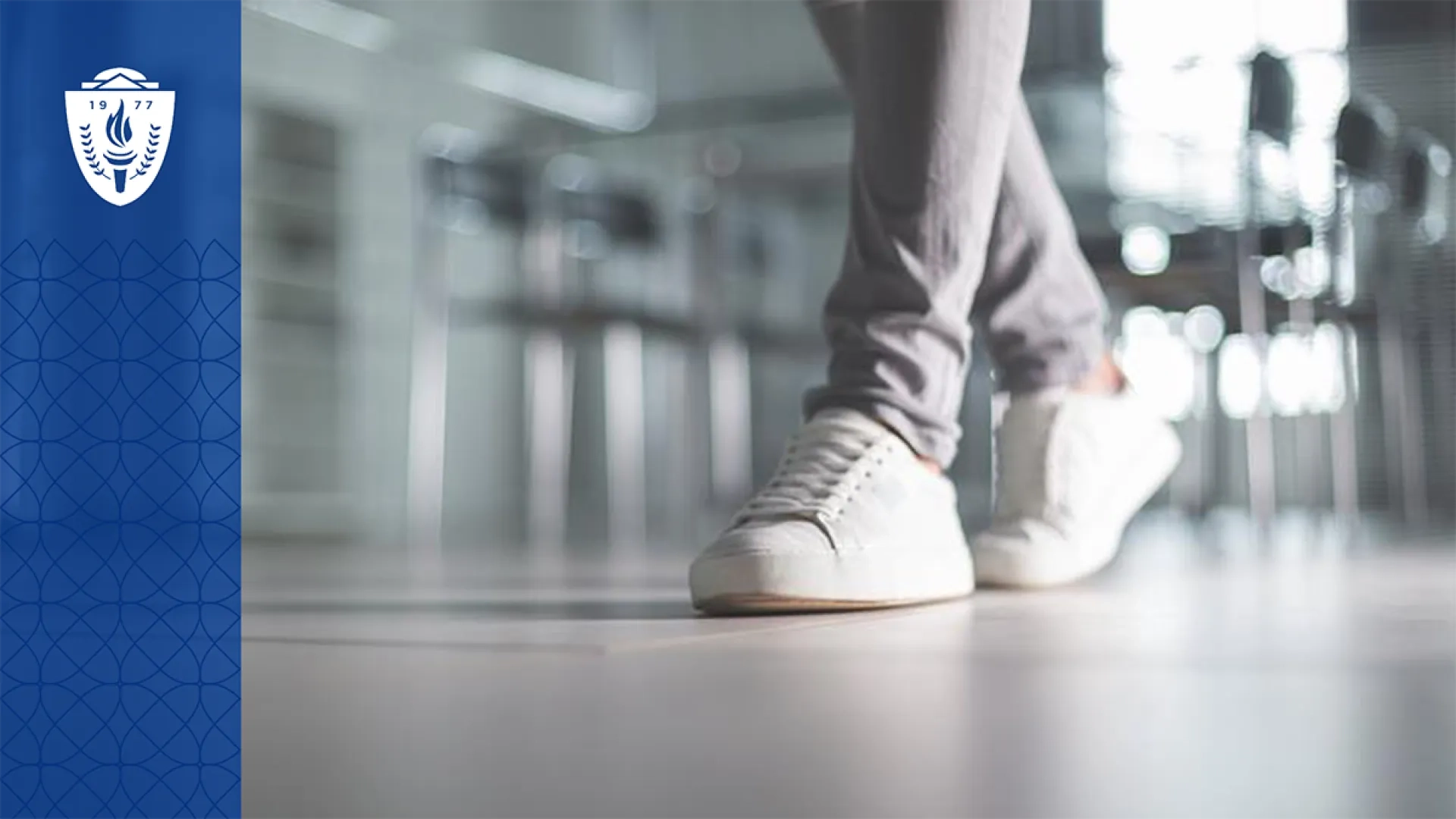 Close up of someone walking in white sneakers and wearing gray pants