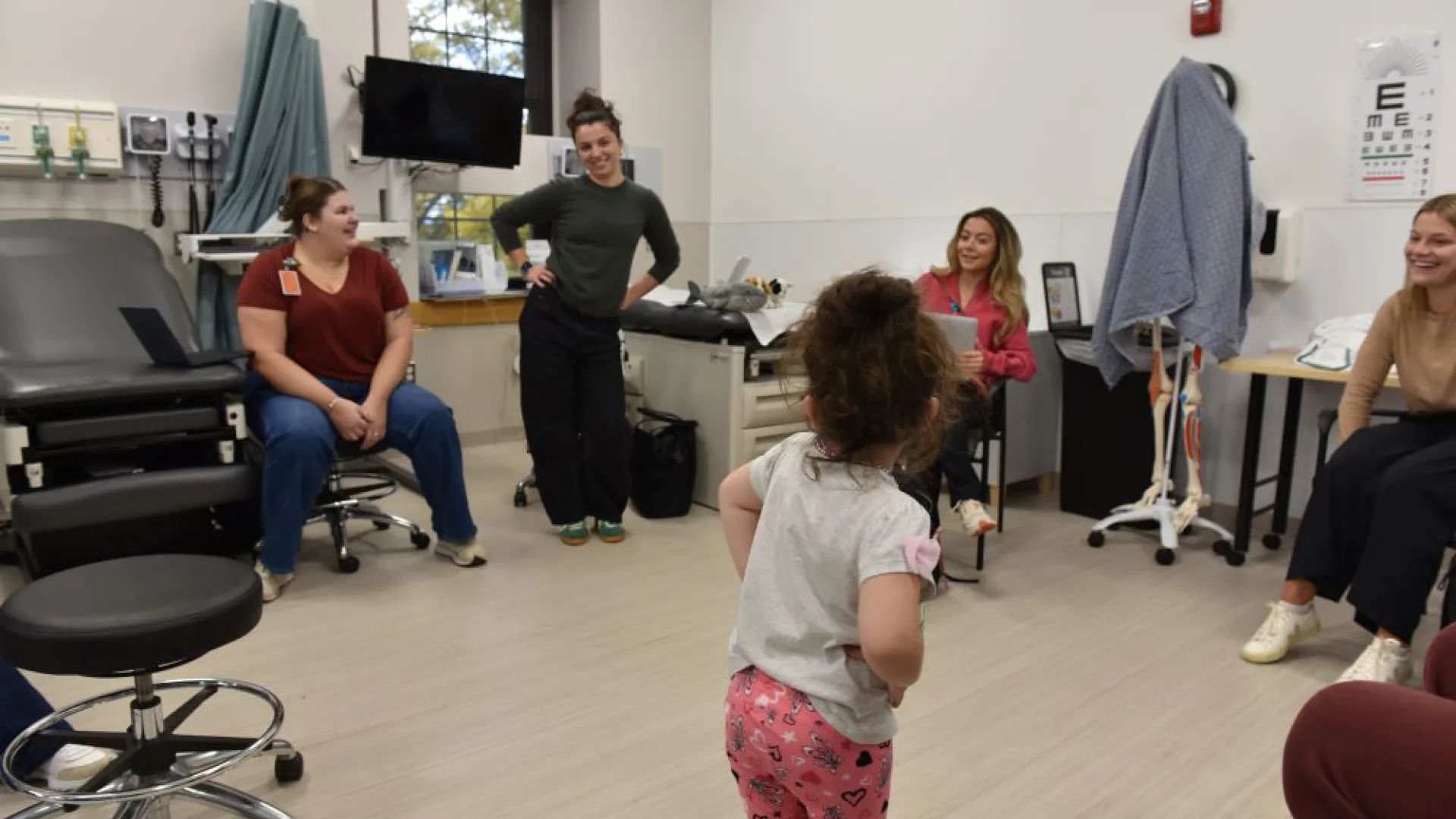 Small child with hands on hips in front of 4 women 