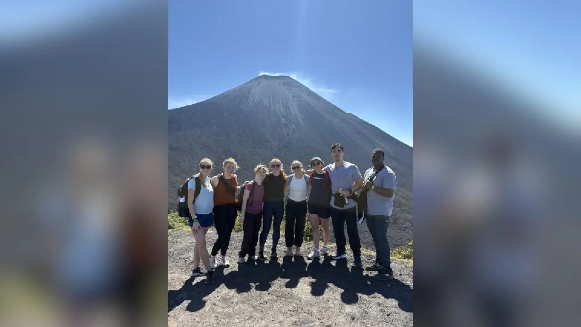 People posing in front of a volcano