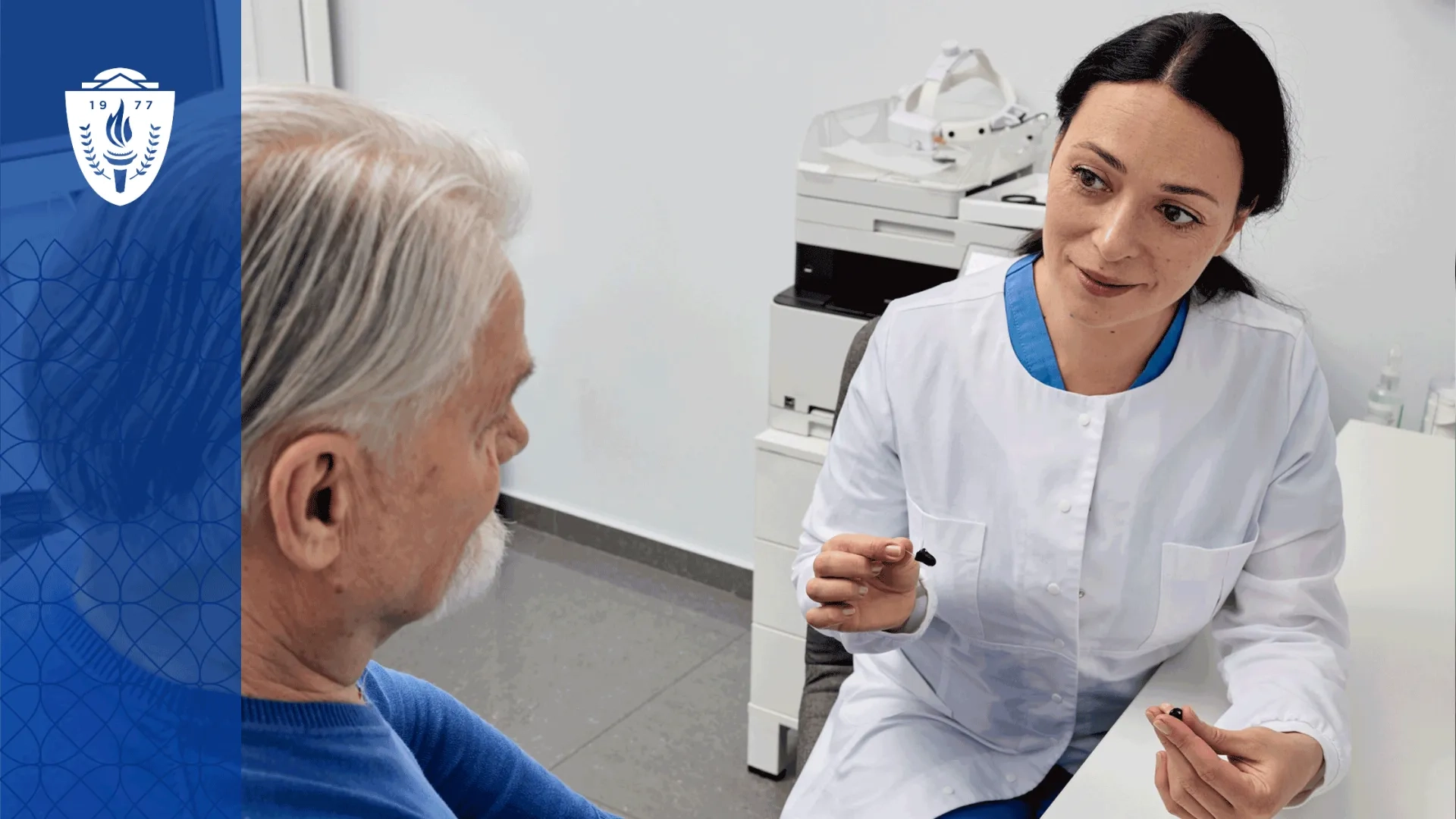 Audiology assistant explaining hearing aid features to an older adult patient