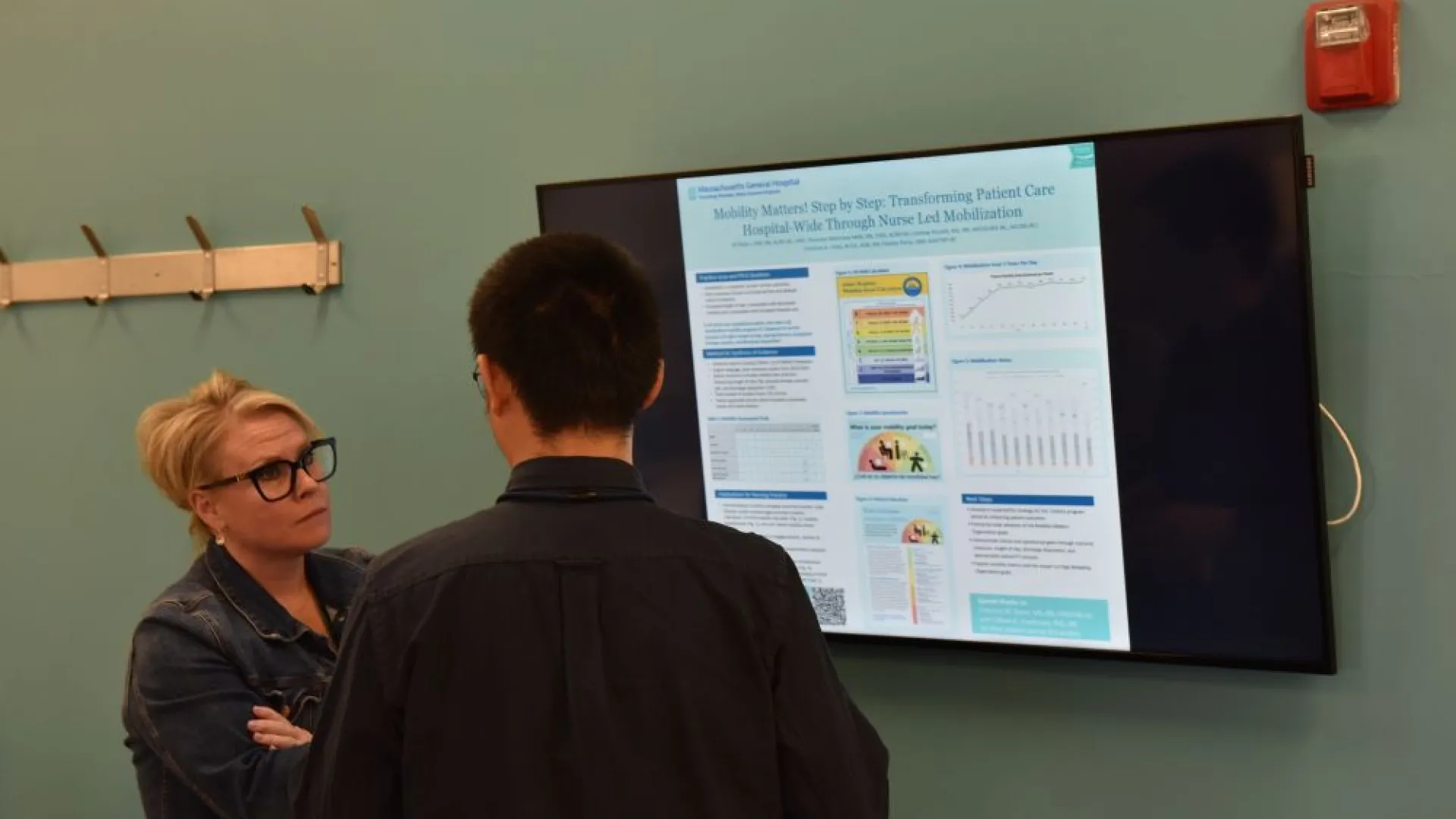 woman speaking to a man in front of a screen 