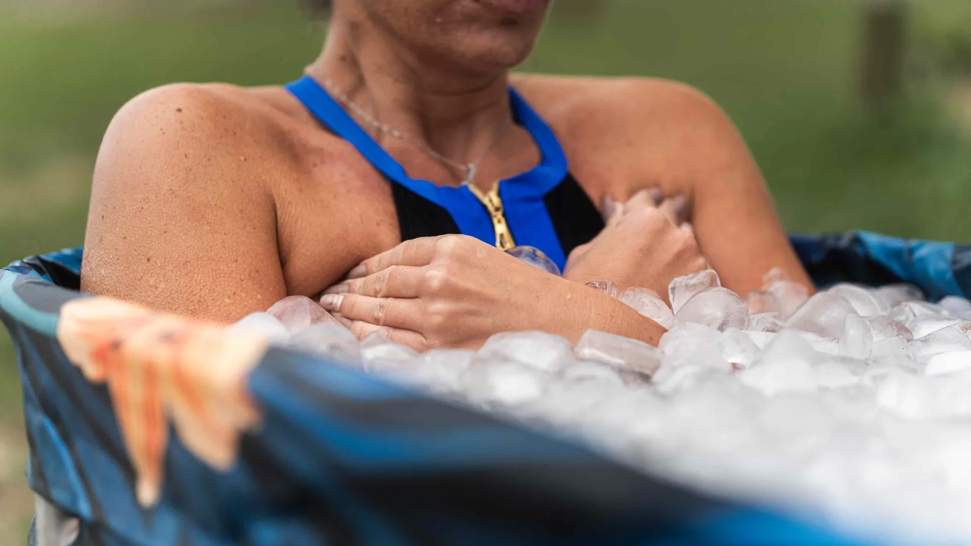 Woman sitting in a tub of ice. 