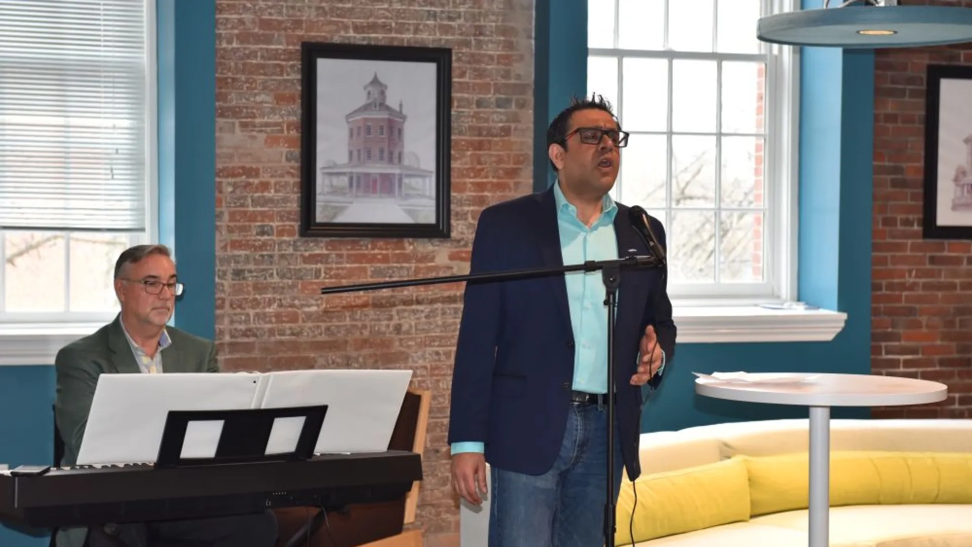 man singing in front of piano