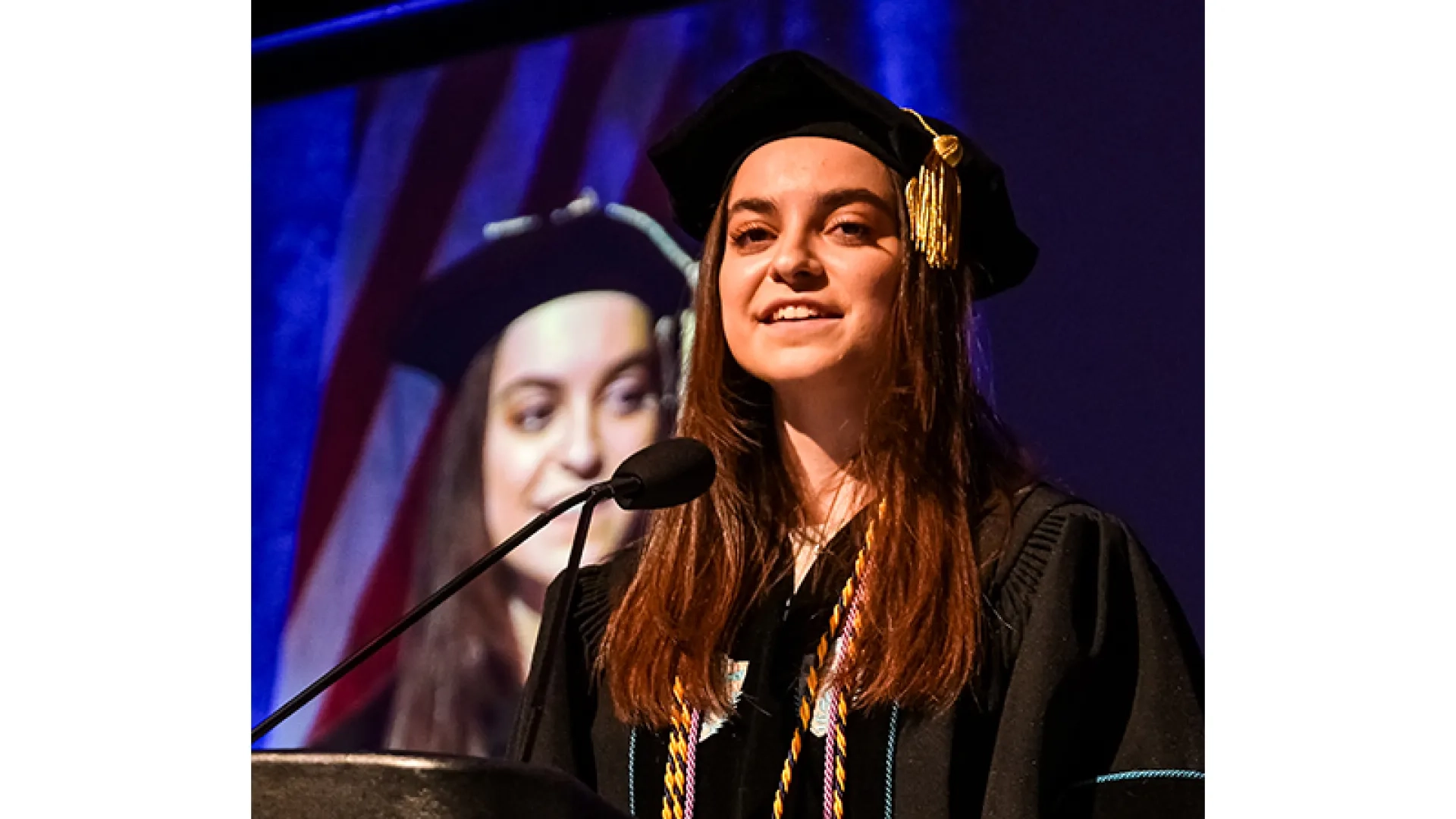 A woman in graduation clothing speaking at the 2026 commencement