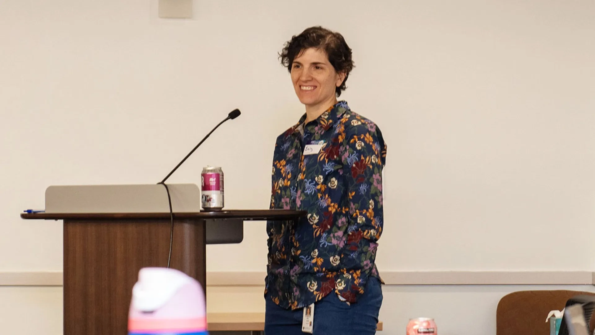 Emily Rosen stands at a podium moderating a panel 