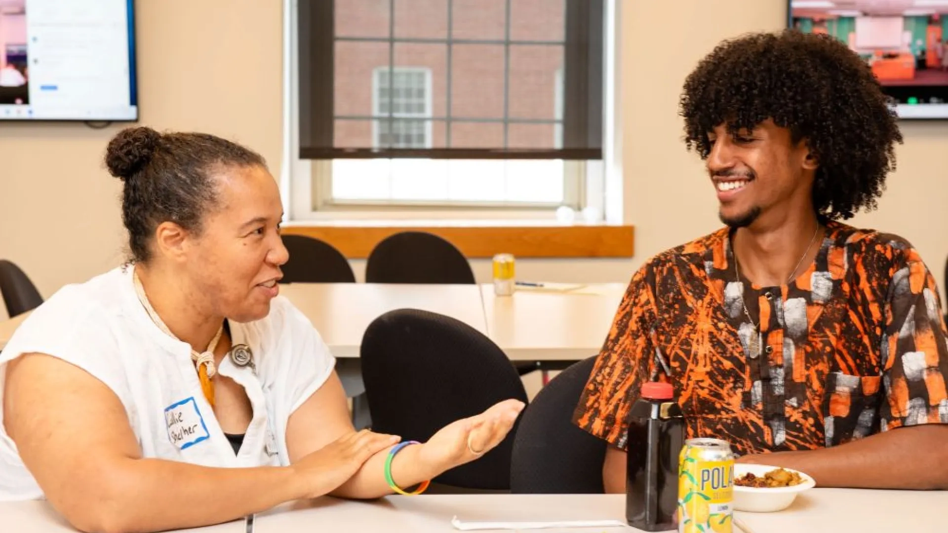 two people sitting at a table having a dicussion facing eachother