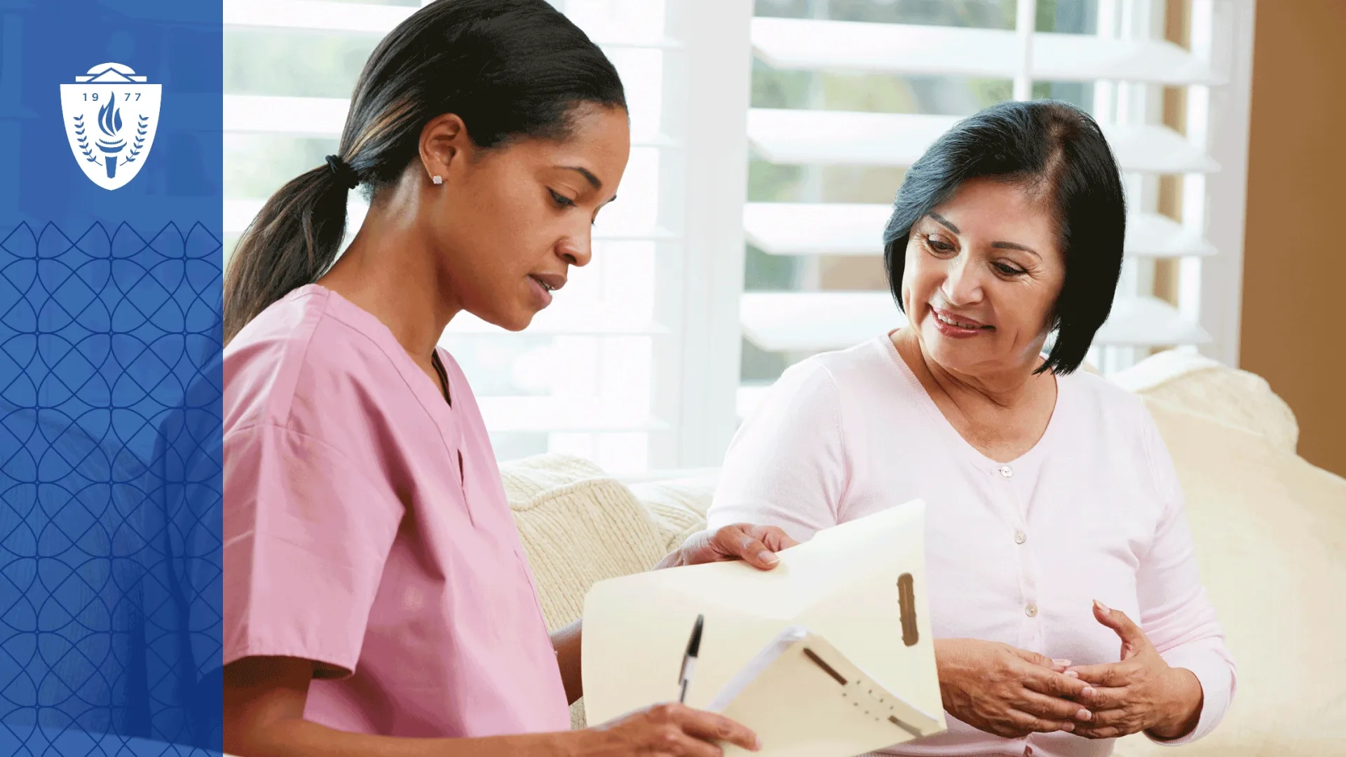 Nurse in pink scrubs looking a printed document with patient.