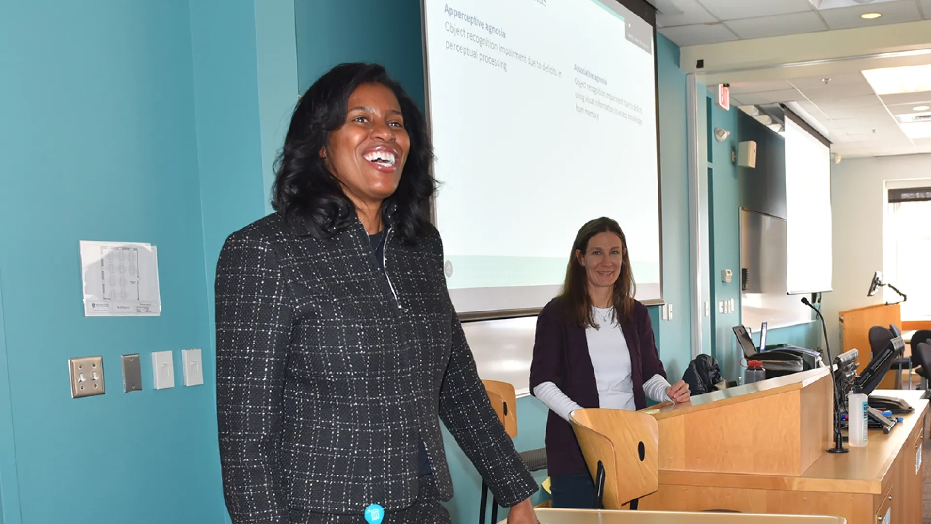 president jones stands and smiles in front of a classroom of students