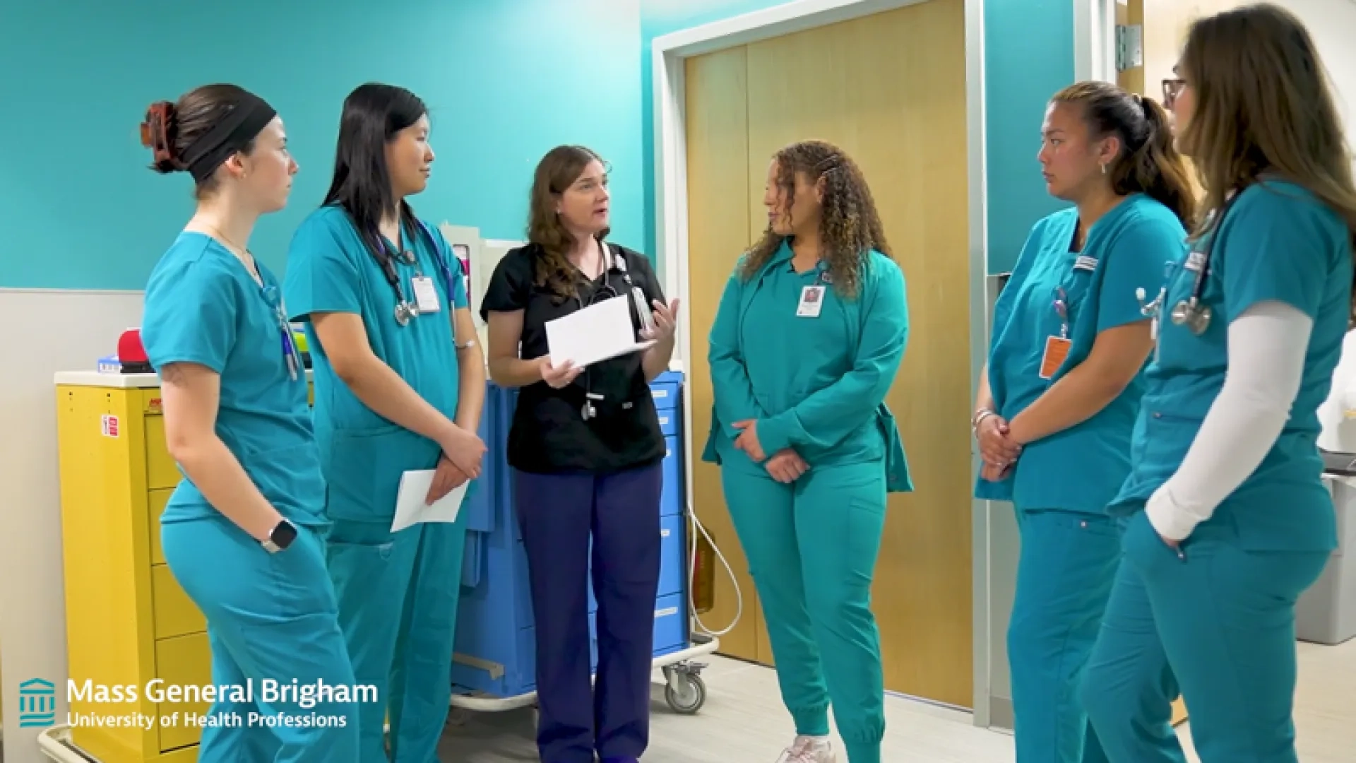 a group of nurses stands in a hospital hallway