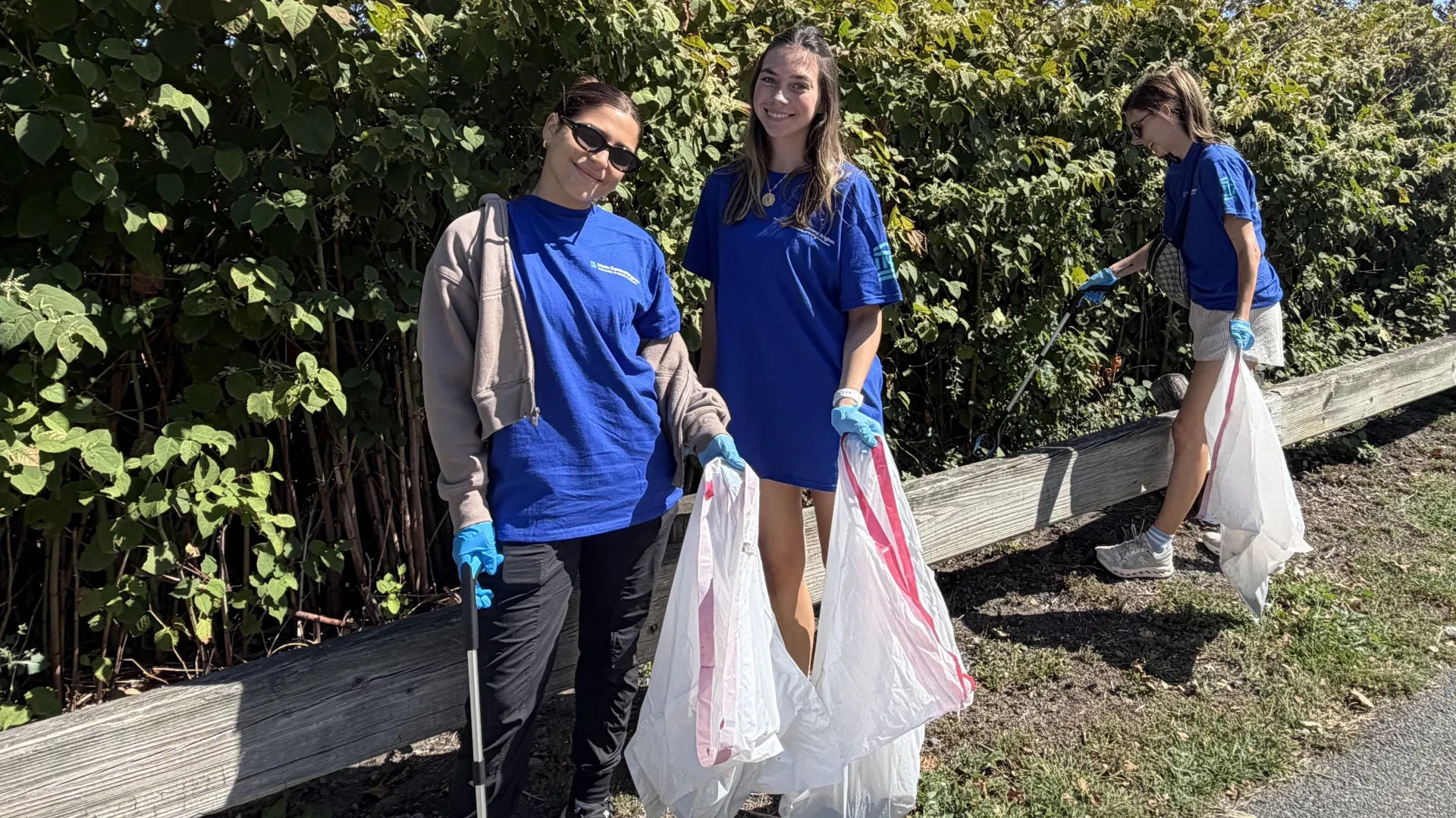 3 people picking up trash 
