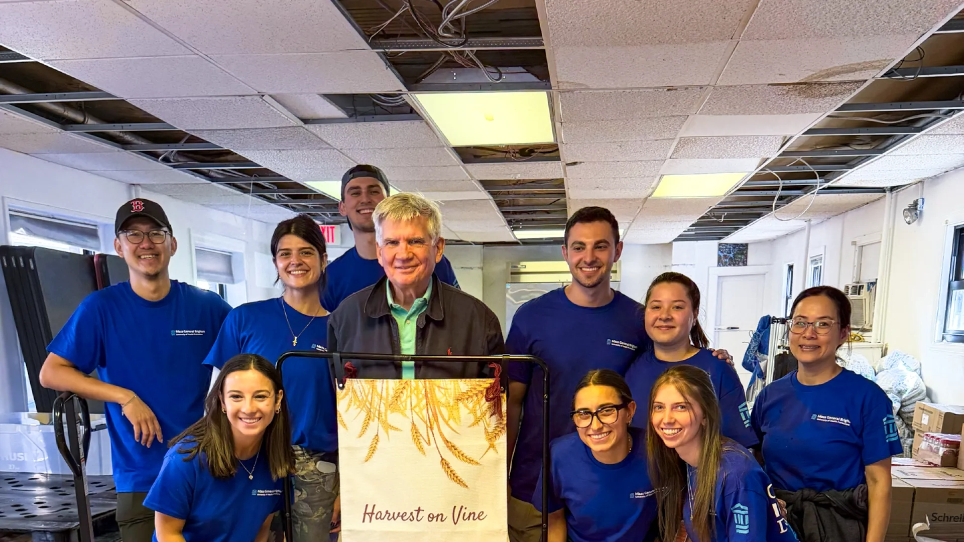 group of people standing in front of a sign that says harvest on vine