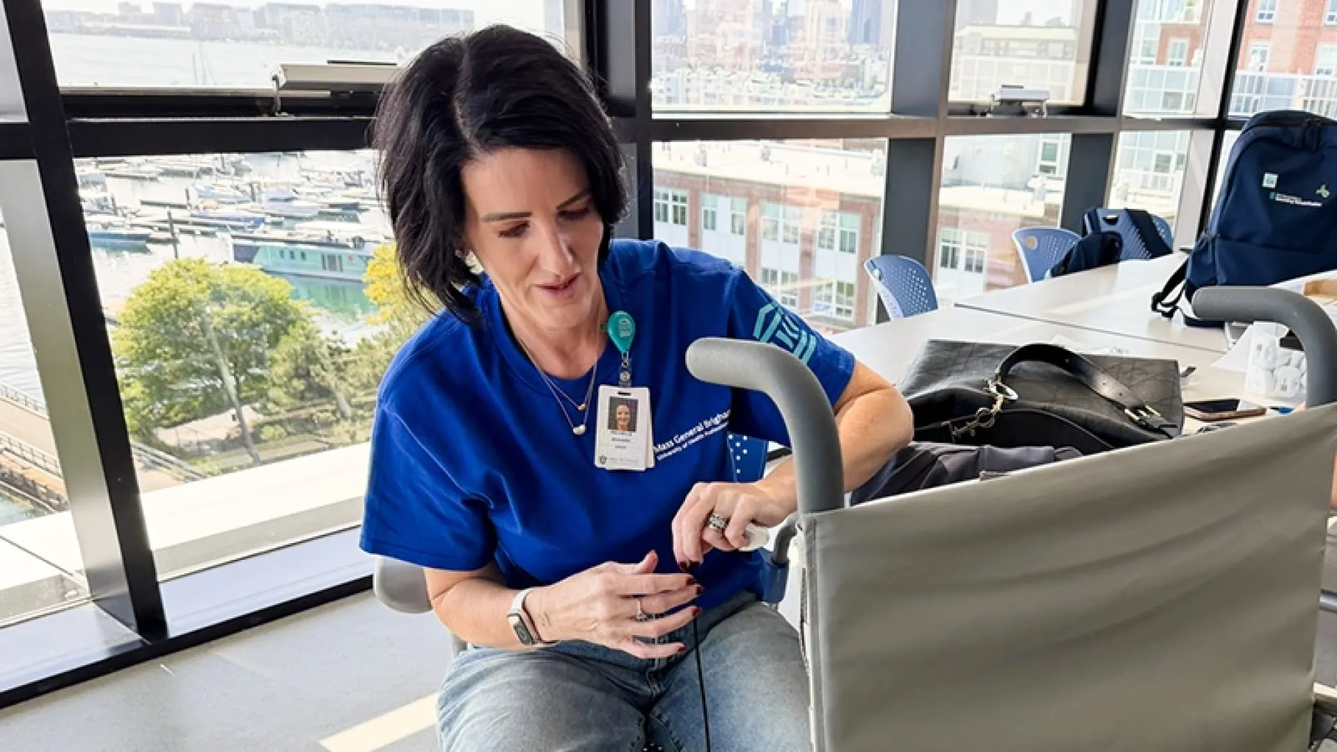 A woman in a blue shirt performs maintenance on a wheelchair