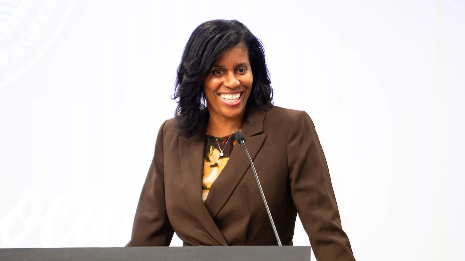 woman standing a podium smiling