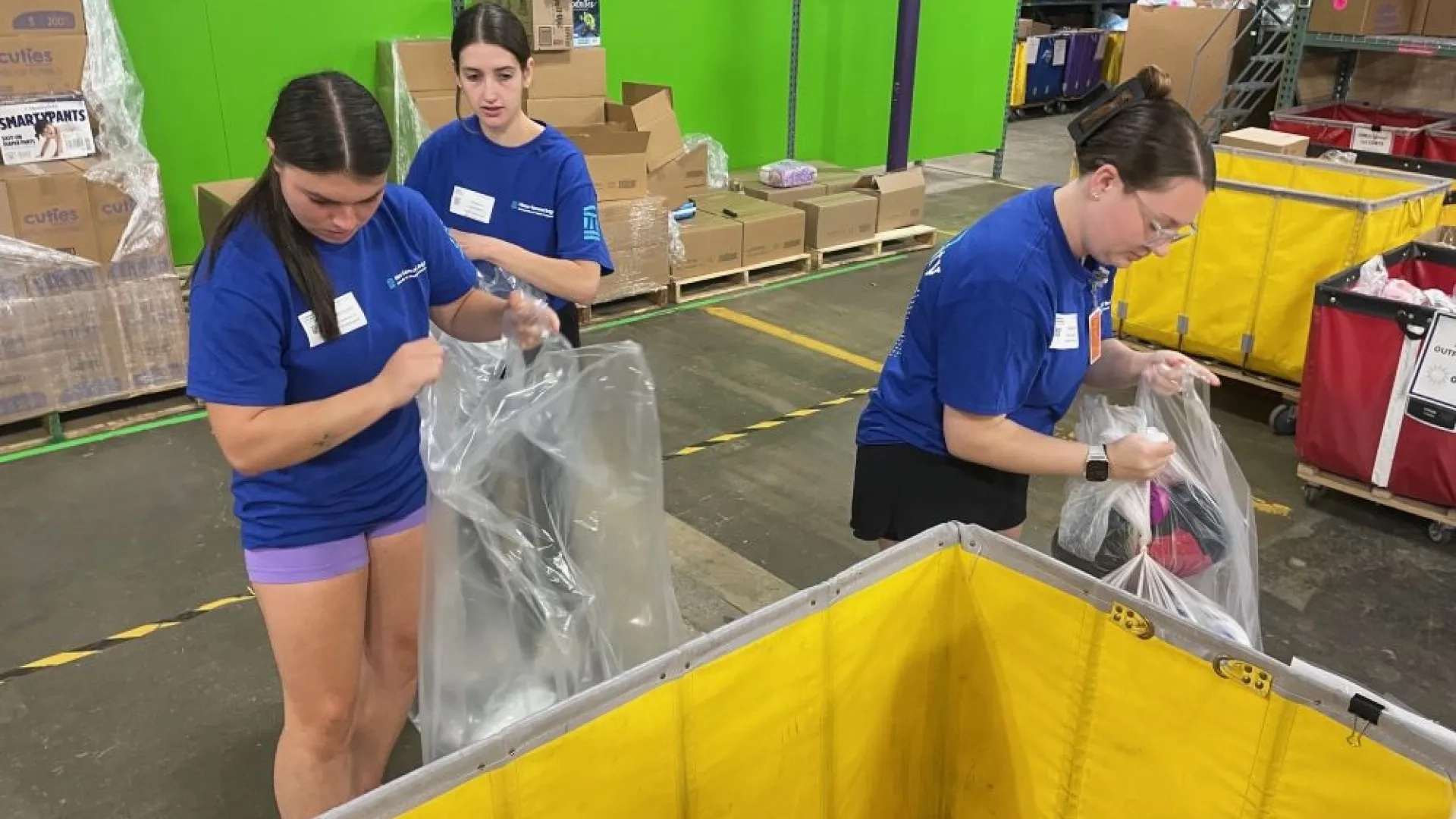 2 women sorting supplies into clear bags
