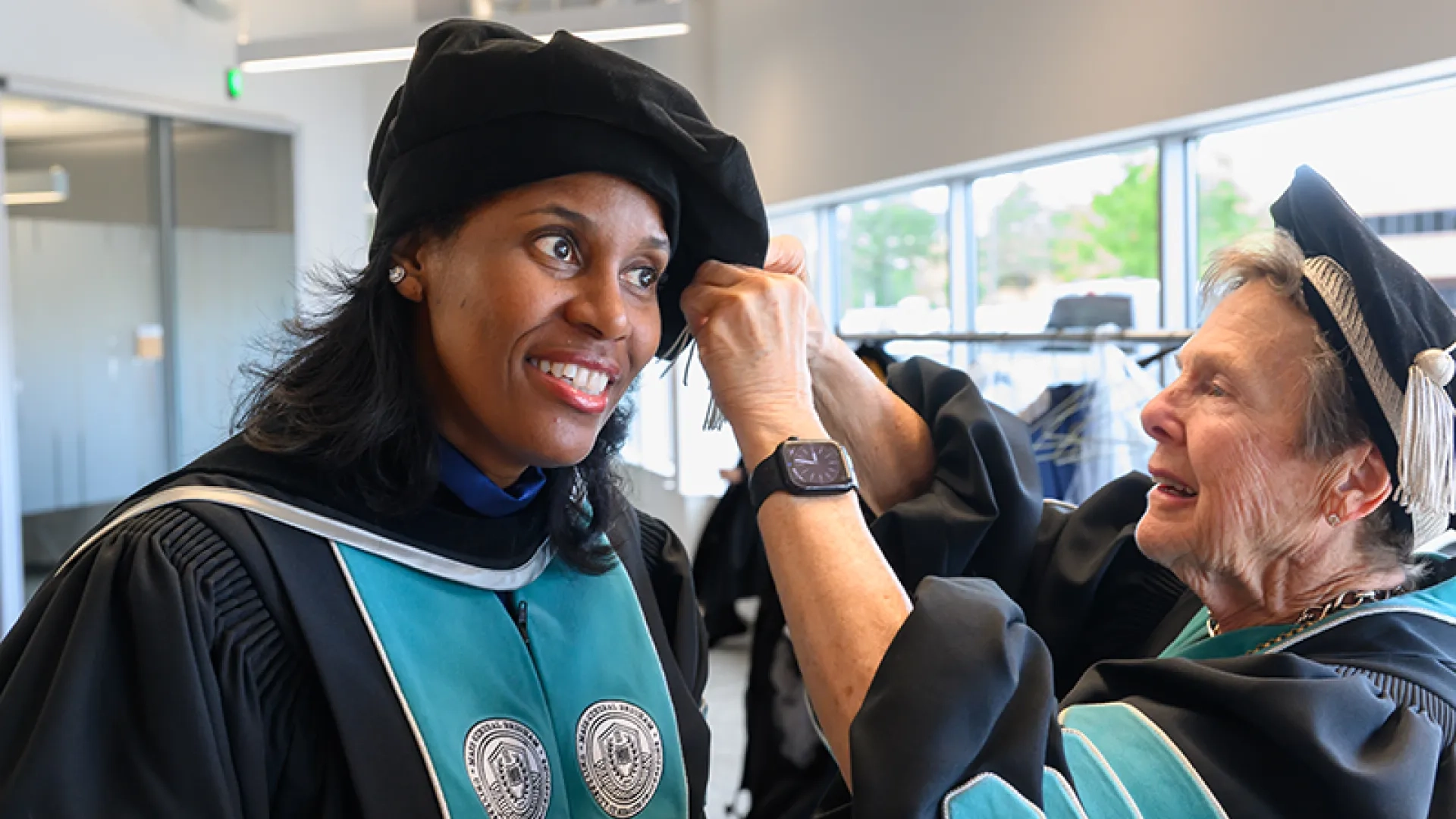 President Emerita Milone-Nuzzo adjusting the tassel of President Jones.  
