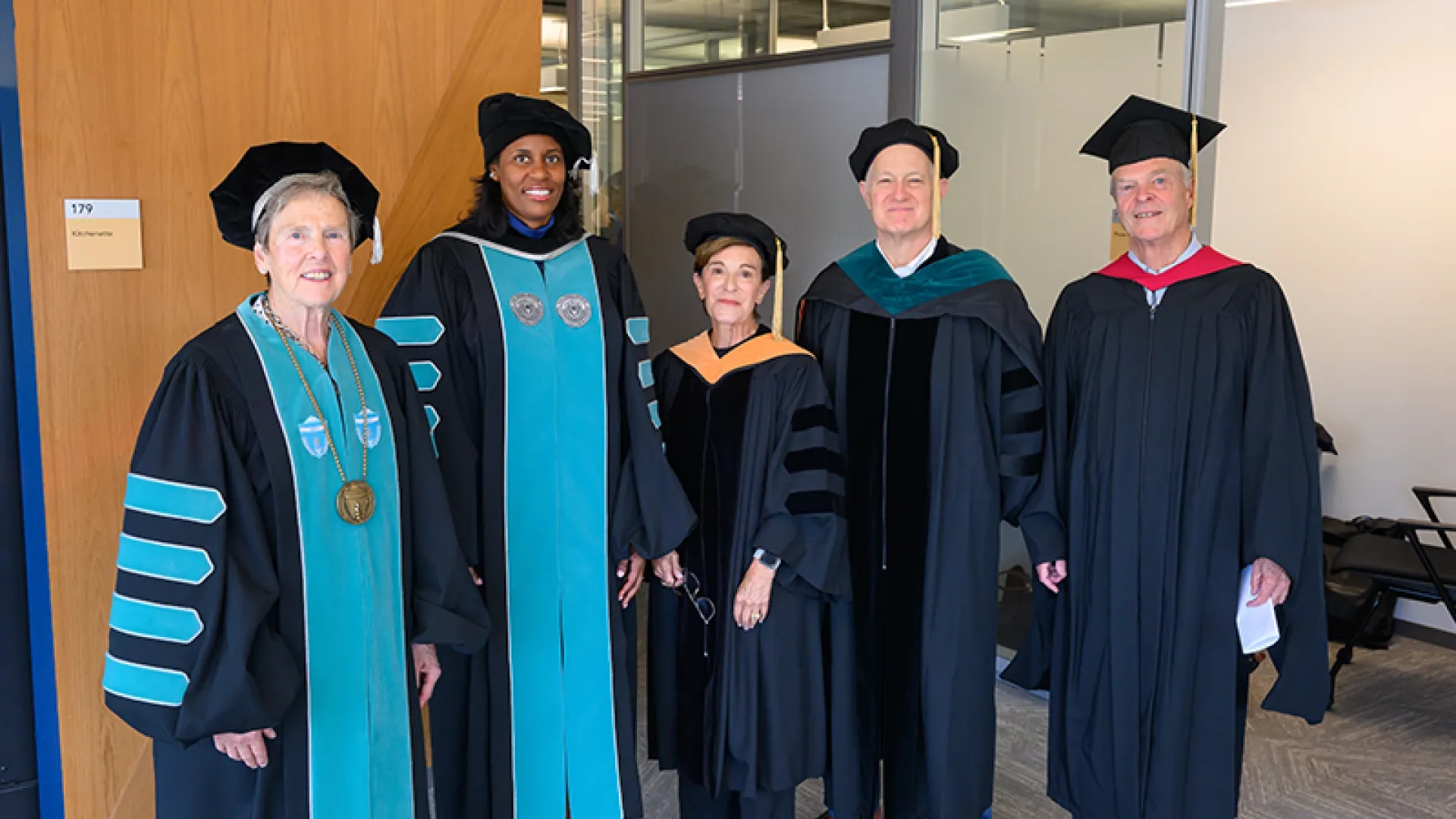  President Deborah Jones puts on her regalia while speaking with President Emerita Paula Milone-Nuzzo