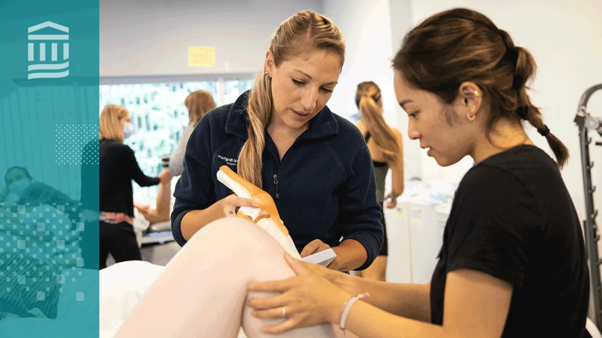 Two physical therapy students practicing hands-on techniques during a lab session, with a focus on joint manipulation.