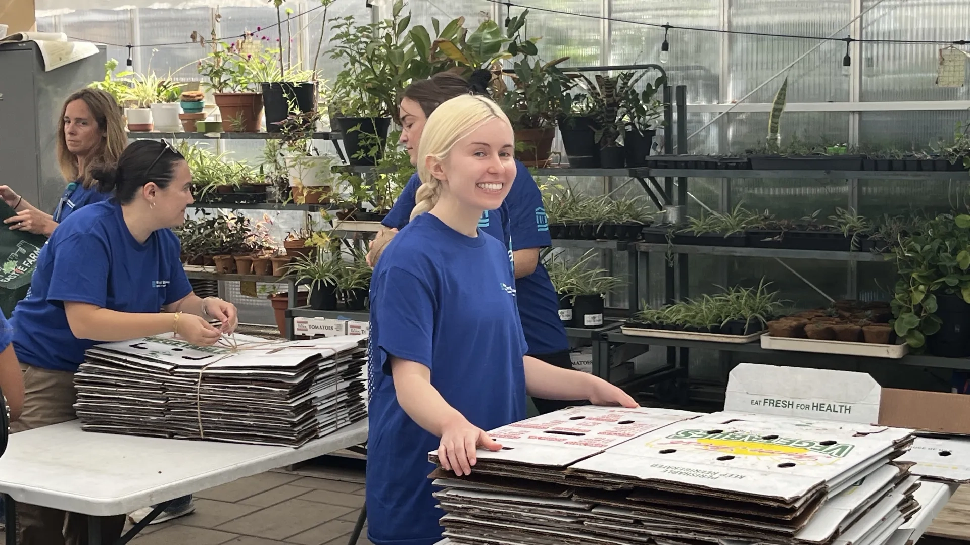 woman standing in front of cardboard flower boxes