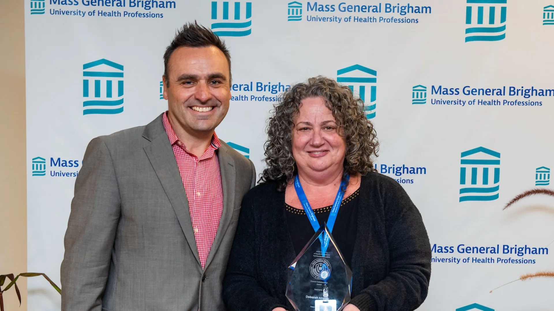 man standing next to woman holding award