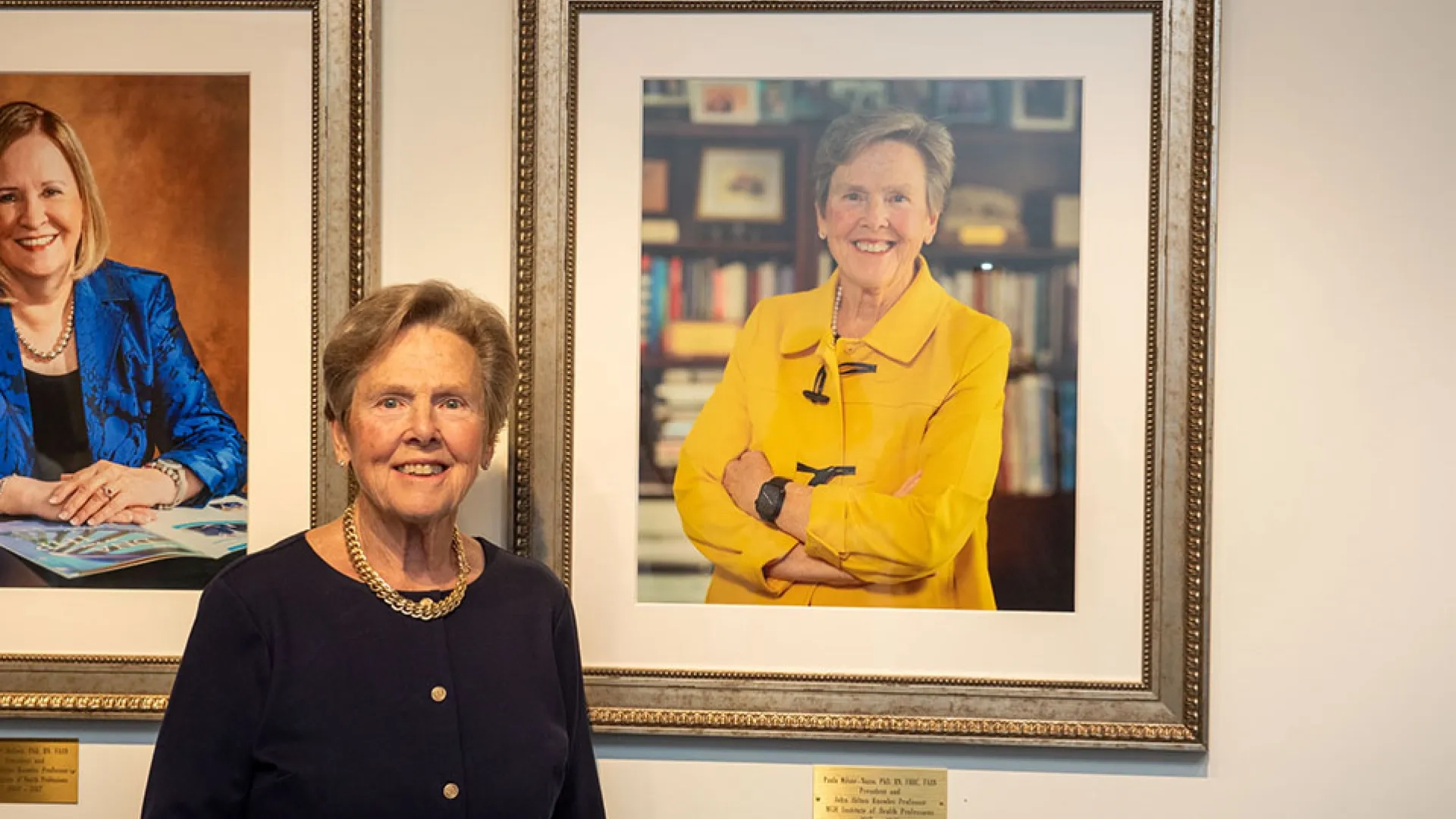 Paula Milone-Nuzzo stands in front of her portrait at the unveiling ceremony