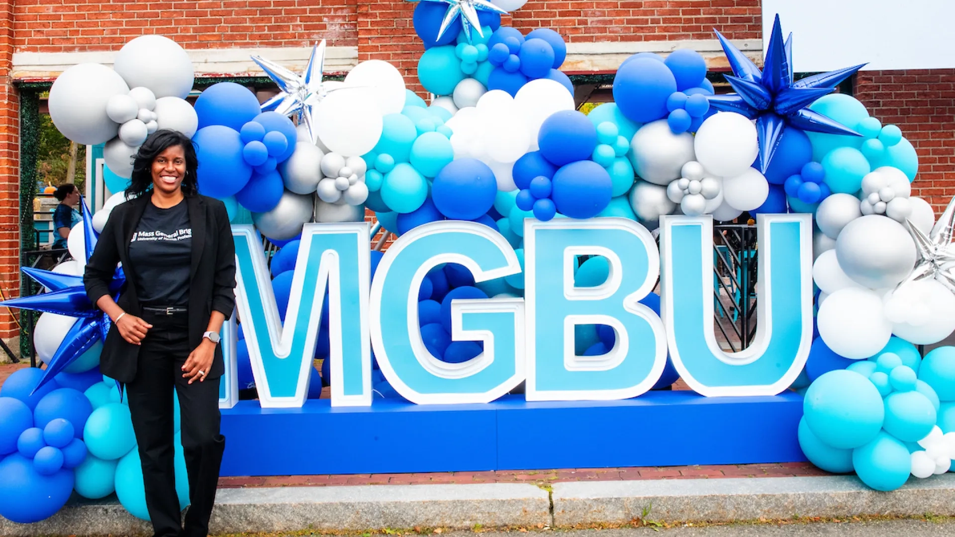 woman standing next to mgbu lettering