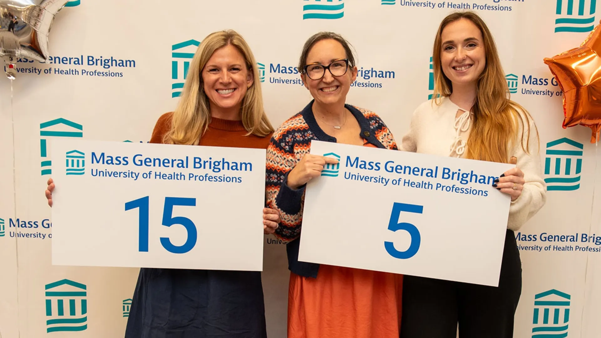 Three women hold up signs with numbers on them