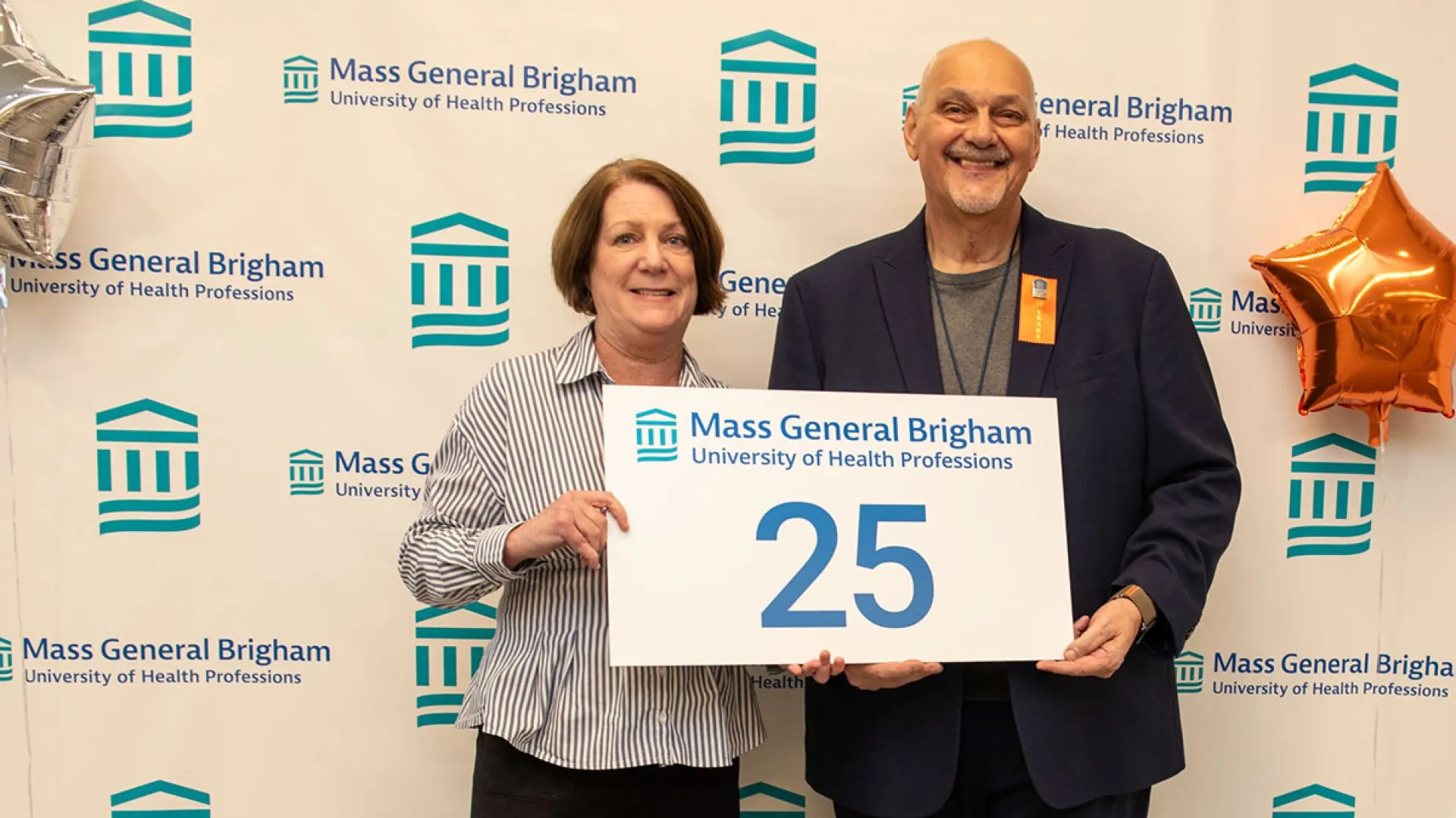 Suellen Breakey and Jim Vitagliano hold a sign with 25 on it