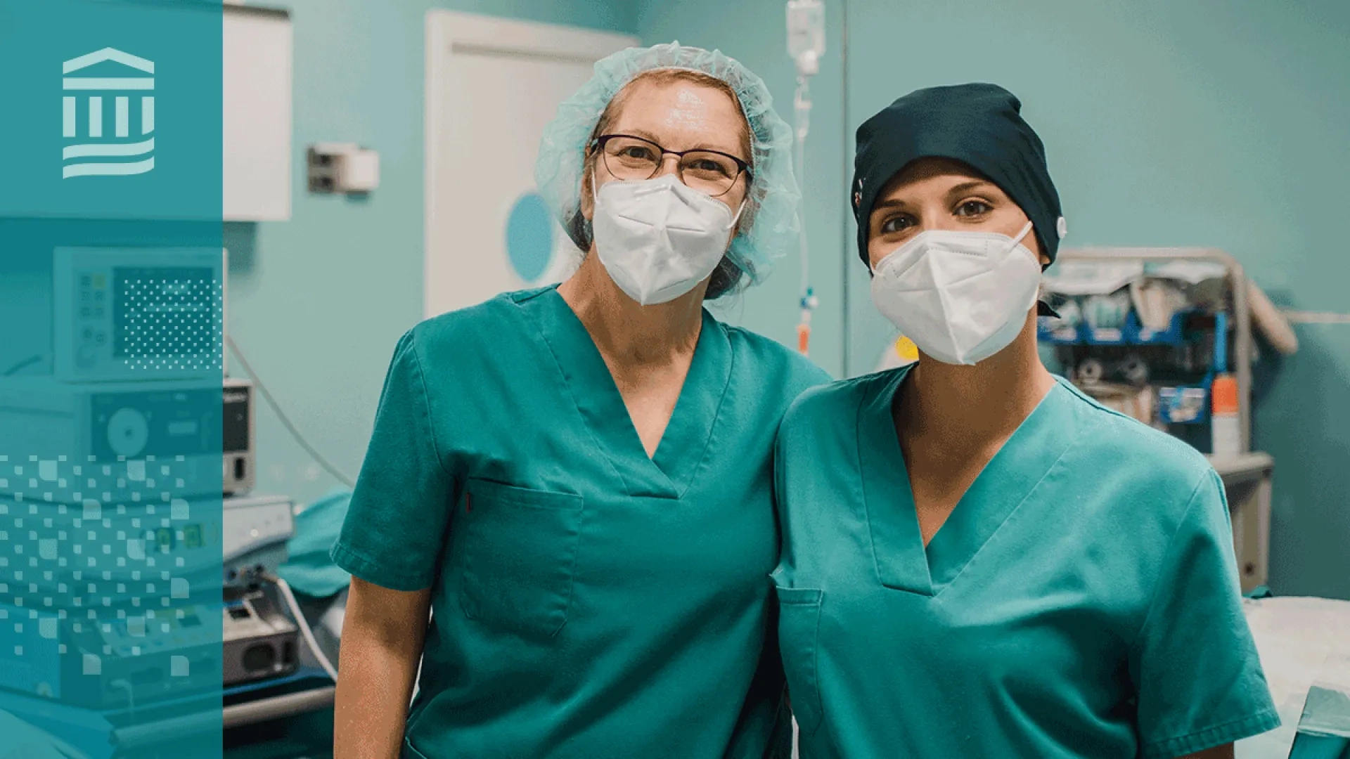 two women with masks and green scrubs stand arm and arm