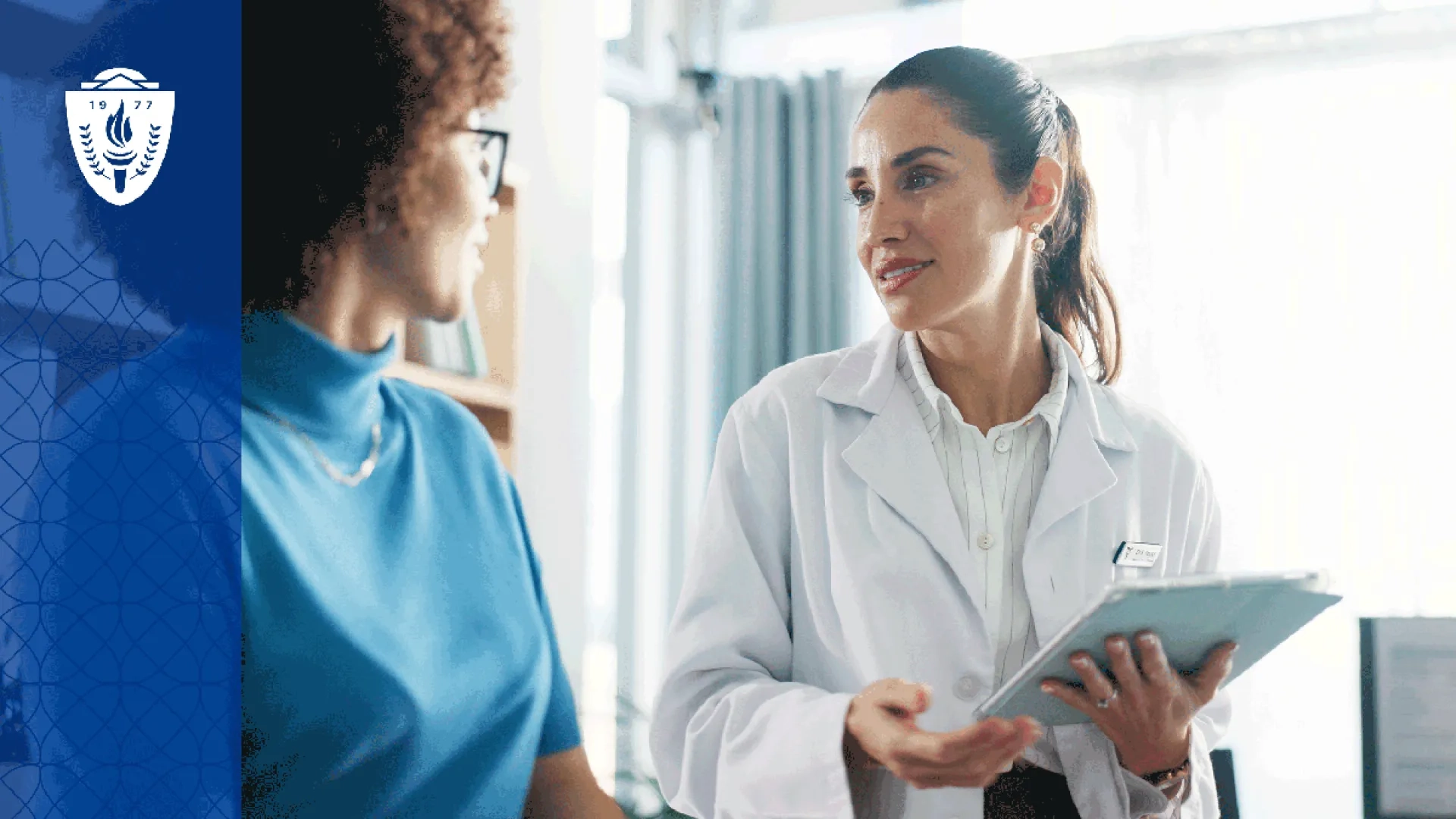 Physical therapy student speaking with a patient in a community clinic setting  A physical therapy student sits at eye level with a patient during a conversation about care goals, emphasizing communication, empathy, and patient-centered care. 