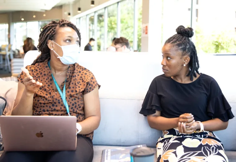 Two women seated on a couch in discussion