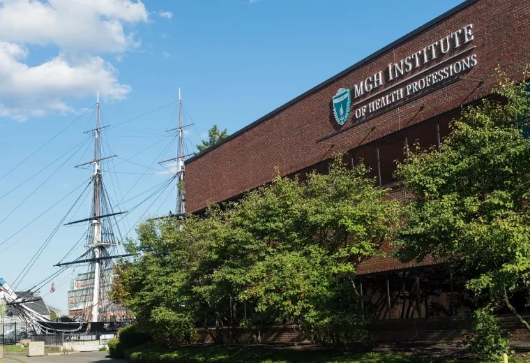 brick building with two mast schooner in the background
