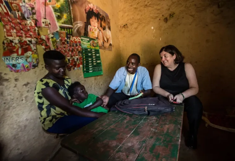 Sheila Davis sits at a table in a concrete room with a Black man, woman and child