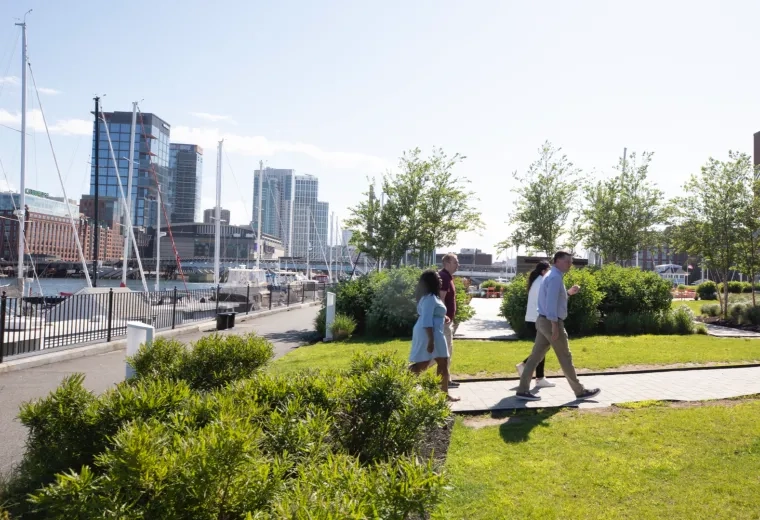 People walking in a park with the waterfront in the background