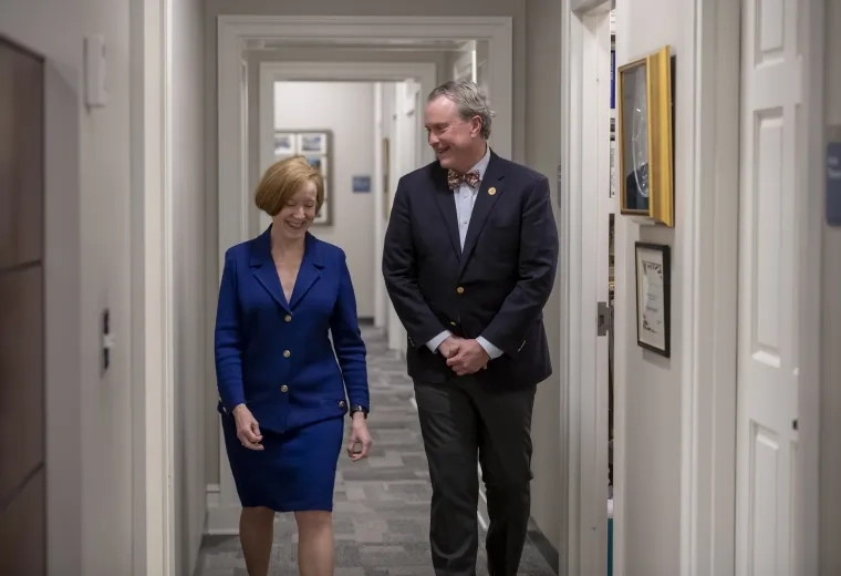debbie and ken walk down a hallway