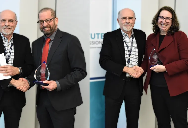tiffany and jordan each shake hands with dr. hilllman while holding their glass raindrop shaped awards