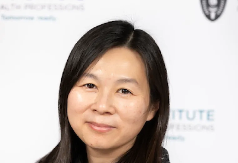 kim has a mottled black cowl neck shirt on and is Asian presenting