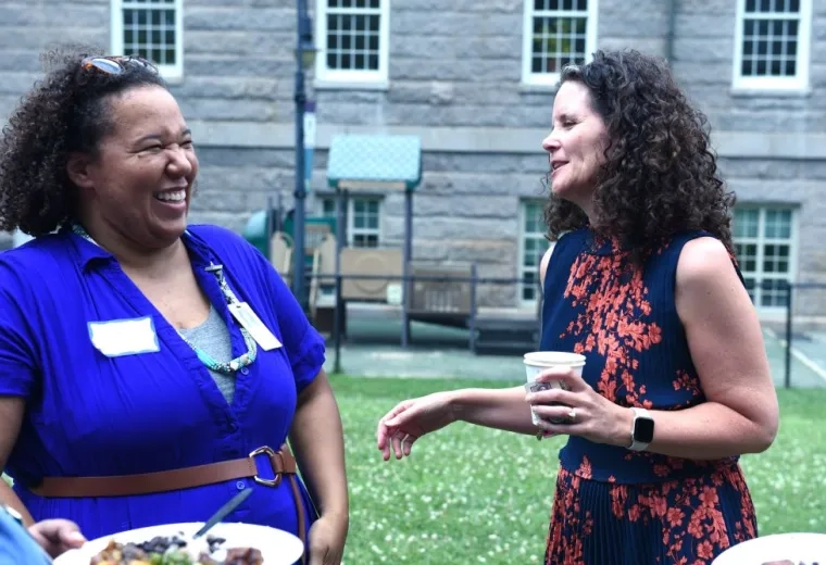 Two women laugh while talking