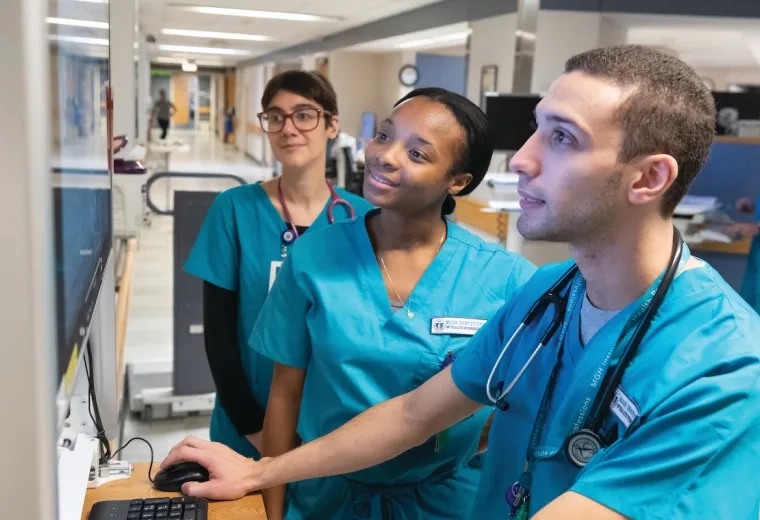 nursing students at a computer in a hospital hallway