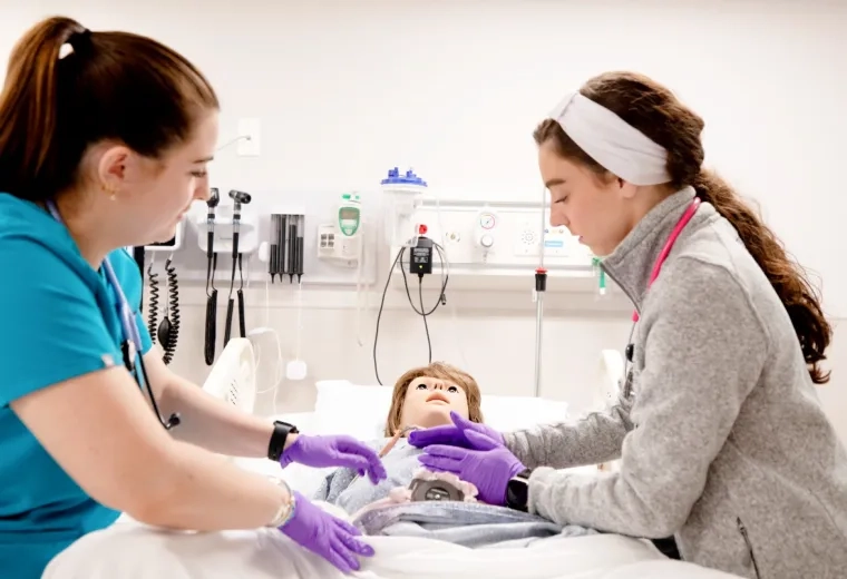 Two nursing students with mannequin baby 
