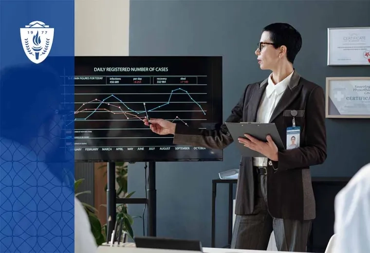 Man presenting at front of room pointing at graph