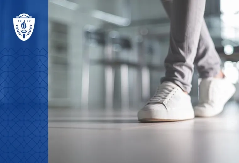 Close up of someone walking in white sneakers and wearing gray pants
