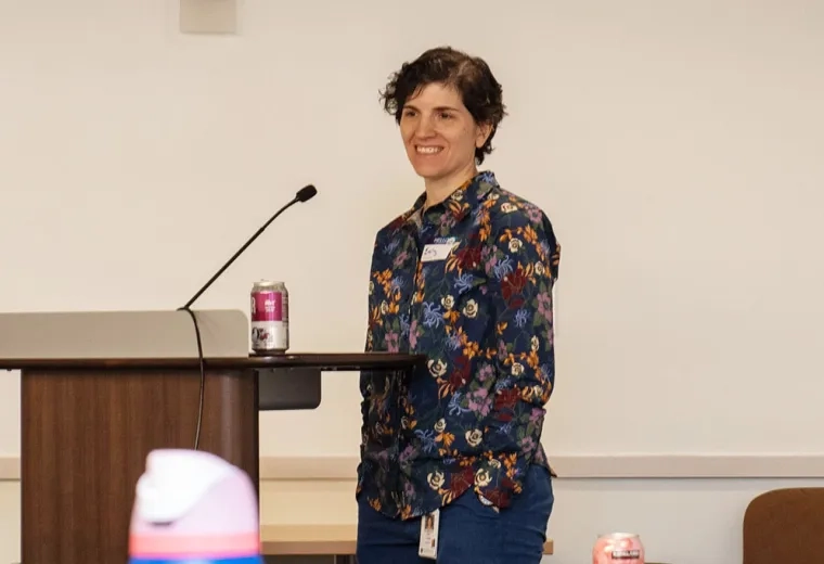 Emily Rosen stands at a podium moderating a panel 