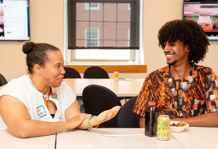 two people sitting at a table having a dicussion facing eachother