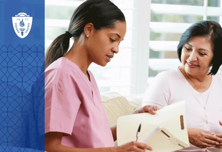 Nurse in pink scrubs looking a printed document with patient.