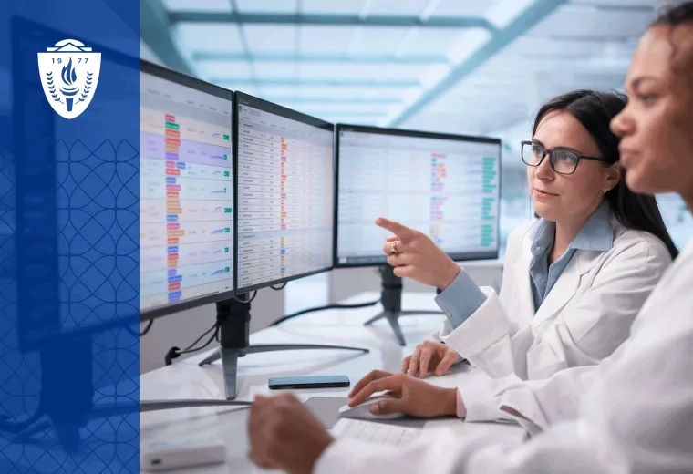 A healthcare educator stands with a small group of nursing and medical learners in a simulation lab reviewing learner analytics on a large display screen. The setting feels collaborative and academic, with realistic clinical equipment and human interaction rather than futuristic technology imagery. 