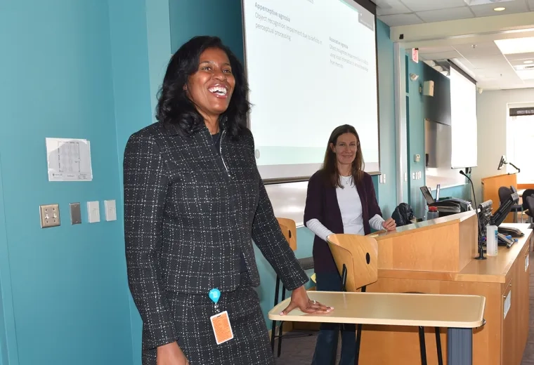 president jones stands and smiles in front of a classroom of students