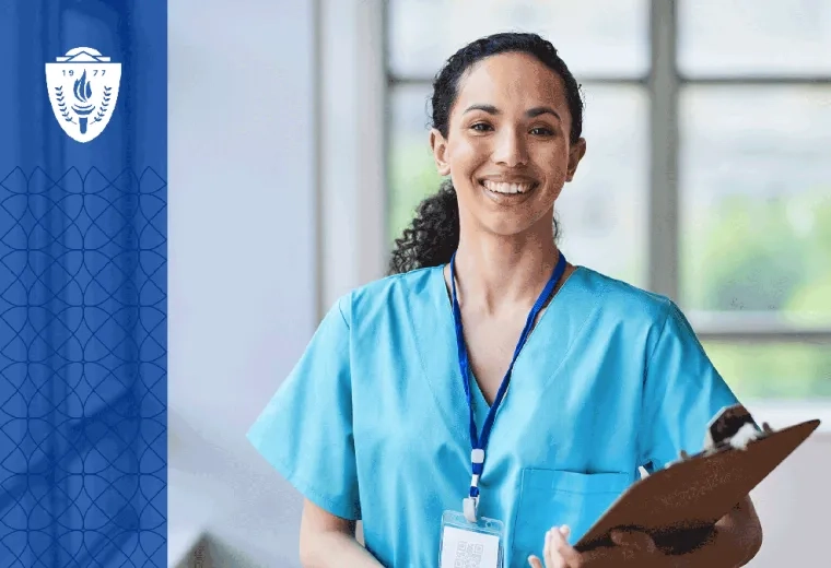 Nursing wearing blue scrubs holding a clipboard and wearing a lanyard around her neck
