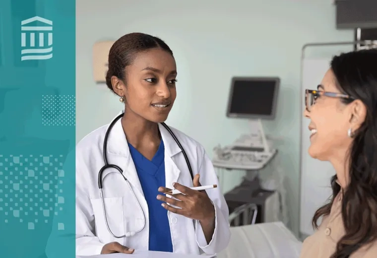 Doctor wearing a white coat and stethoscope talking to woman