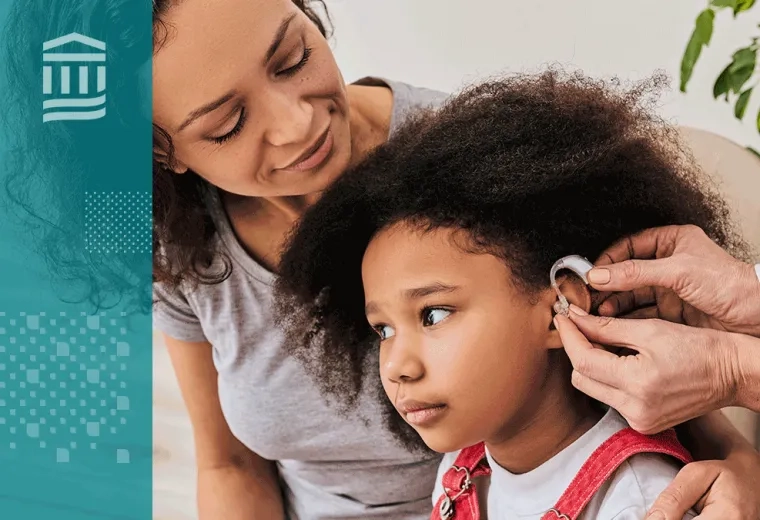 woman has arm around her daughter who is getting fitted for a hearing aid